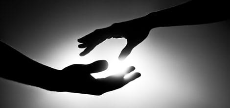 Silhouette of two hands reaching for each other